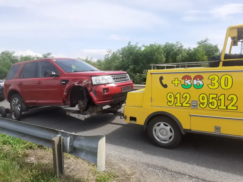 Autómentő sérült piros SUV mentése közben